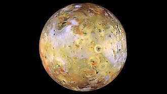 This image shows Jupiter's moon Io, taken from the Galileo spacecraft. It looks like a yellowish pockmarked world on a black background.
