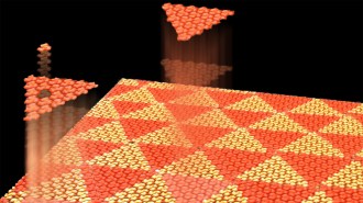 In this illustration, a flat plane is made up of orange and red triangles, with smaller molecules within the triangles rotated to create irregular patterns.