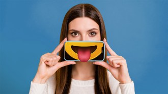 a composite with a women holding a phone in front of her mouth. the phone has an image of a smiley face with tongue out.