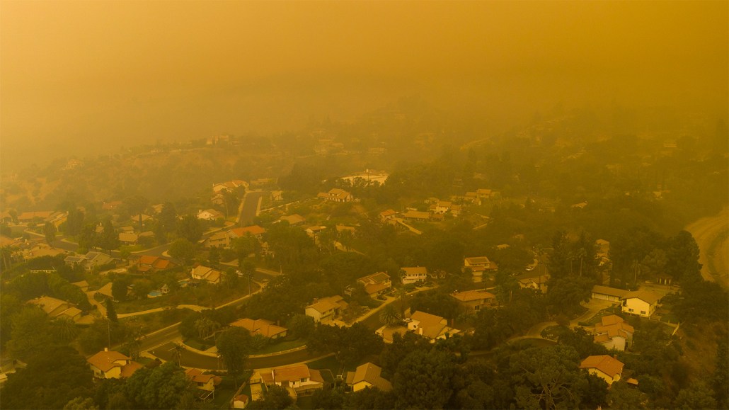 An orange haze from wildfire smoke hangs over a Los Angeles neighborhood. A new study says such fires boost ground-level ozone pollution levels.