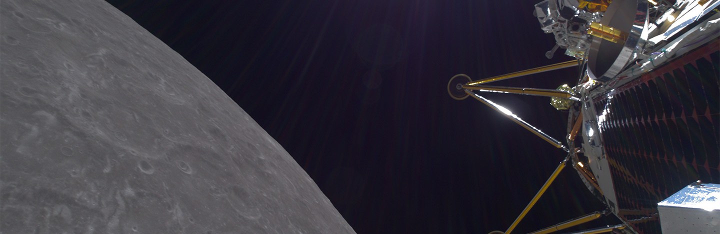 The legs of a lander against the blackness of space, the moon at lower left