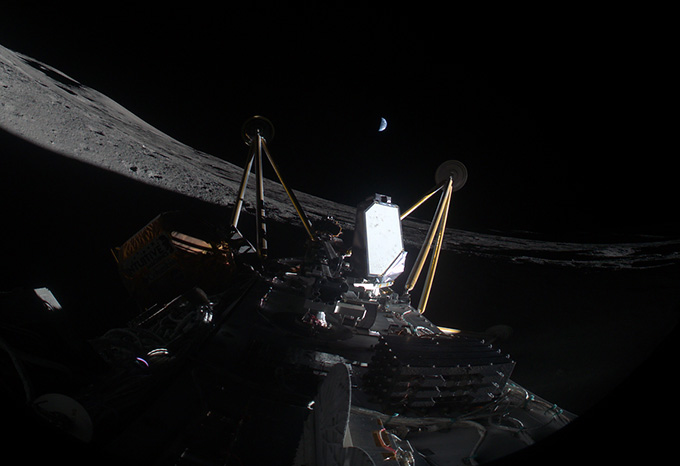 Intuitive Machine's moon lander, Athena, is seen lying on its side on the lunar surface, with a crescent of Earth visible in the distance.