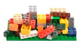 A pile of multi-colored legos, some stacked, some jumbled haphazardly. The image illustrates a book review of Memory Lane by Ciara Greene and Gillian Murphy.