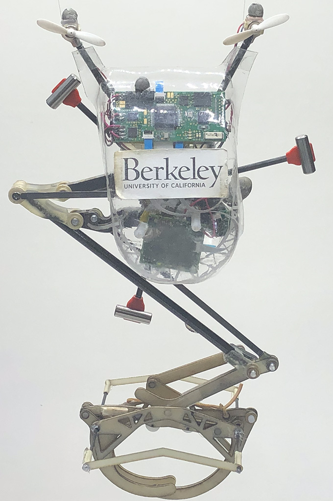 A spindly robot with a gripper foot and a sticker labeled Berkeley University of California.