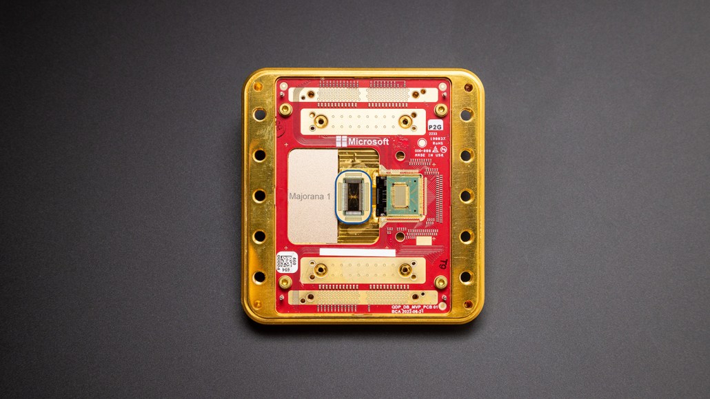 A square, red and metallic device labeled "Majorana 1" sits on a gray background.