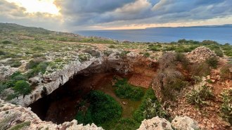 The cave entrance to a Stone Age archaeological site on Malta. The Mediterranean sea is in the background.