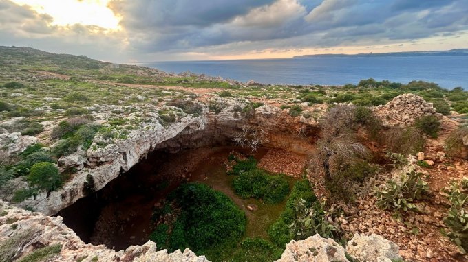 The cave entrance to a Stone Age archaeological site on Malta. The Mediterranean sea is in the background.