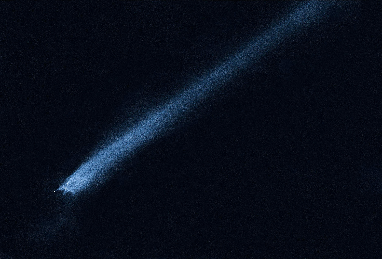 A streak of white, speckled light spans from across a mostly black image. At one end of the band, the light ends abruptly with the suggestion of dark, roundish shape.