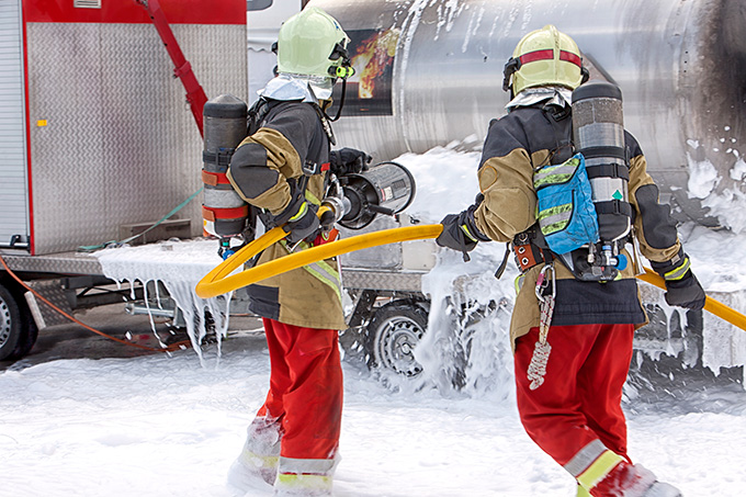 Fire fighters use a foam to combat a fire.