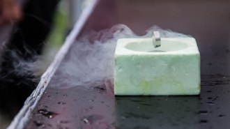 A cylindrical magnet floats above a styrofoam container surrounded by a haze.