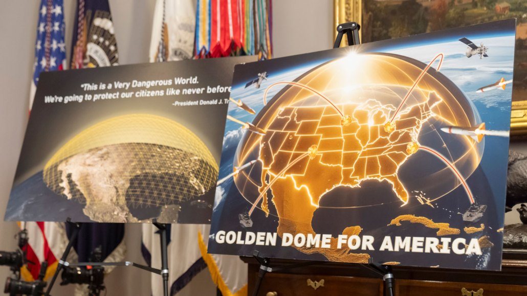 Two posters show conceptual illustrations of the Golden Dome missile defense system.