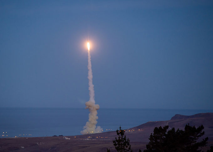 A missile interceptor climbs through the sky with a plume behind it.