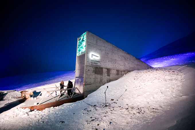 The brutalist concrete entrance to the Svalbard Global Seed Vault, an underground seed bank in Norway, juts out of a snowy hillside.