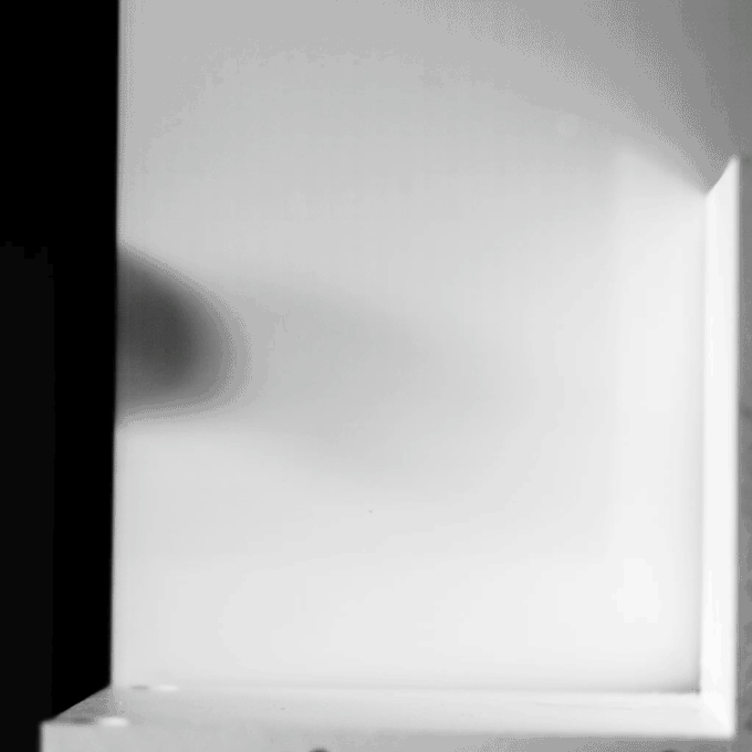 A squash ball hits in a wall in slow motion.