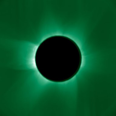 A black circle perfectly blocks the sun in an artificial solar eclipse. The sun's corona and wispy rays radiate from it in dark green.