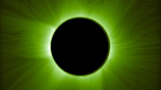A black circle perfectly blocks the sun in an artificial solar eclipse. The sun's corona and wispy rays radiate from it in lime green.