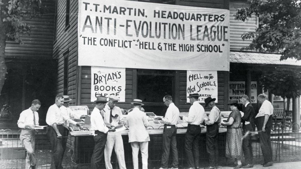 A black-and-white photograph showing people browsing books at a an Anti-Evolution League stand in Dayton, Tenn., where the Scopes trial took place in 1925