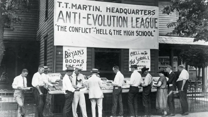 A black-and-white photograph showing people browsing books at a an Anti-Evolution League stand in Dayton, Tenn., where the Scopes trial took place in 1925