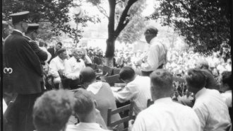 Two people having a discussion among a crowd of people watching.