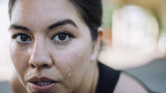A closeup of a woman's face that's covered with sweat.