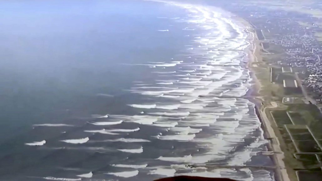 waves are shown from above moving towards a coastline