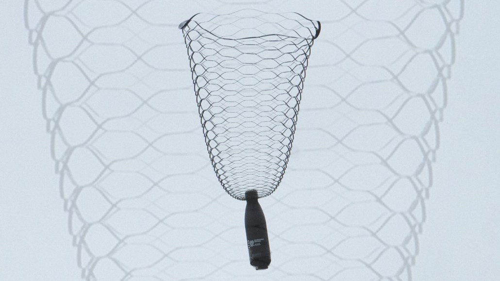 A water bottle dangles from a lacy, vase-shaped parachute.