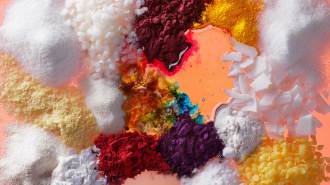 a photograph of different types of foods, seasonings, oils and food dyes on an orange background