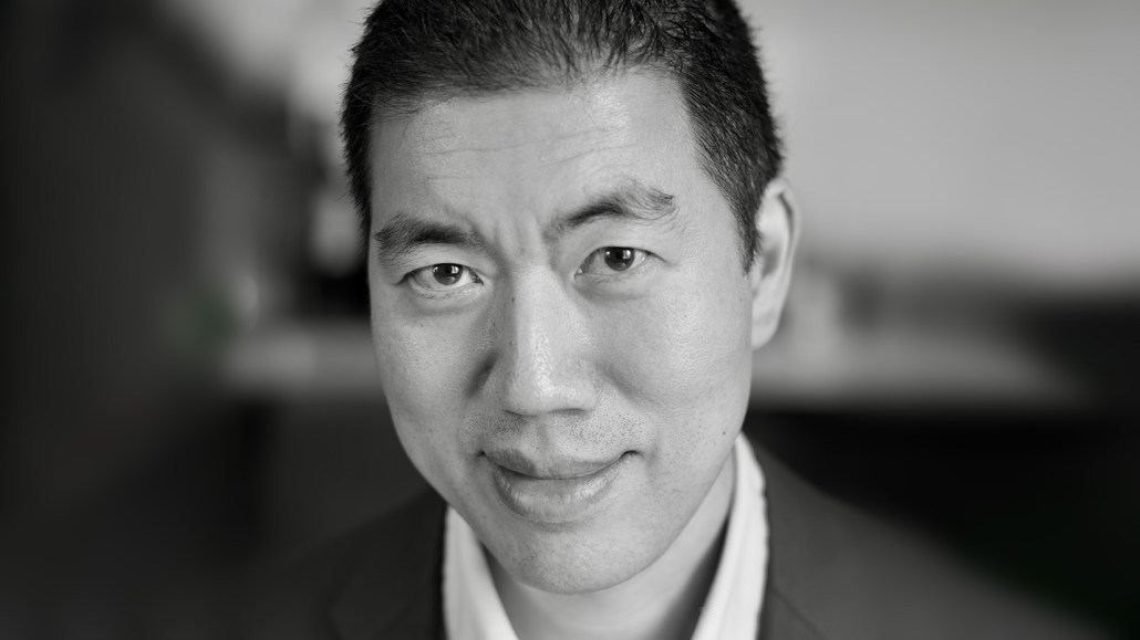 David Liu, Harvard professor of organic chemistry, gazes into the camera and smiles in this black and white photo.