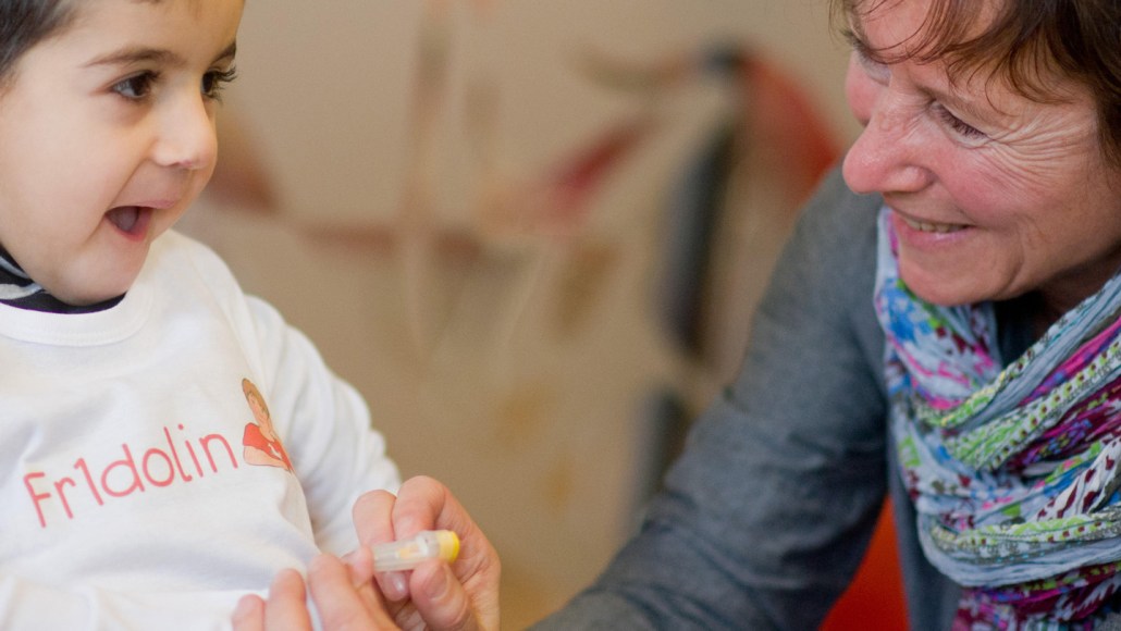 A nurse pricks a child's finger to take a blood sample from a child.