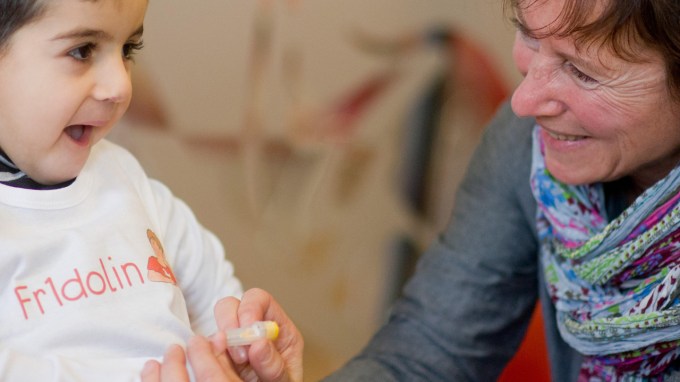 A nurse pricks a child's finger to take a blood sample from a child.