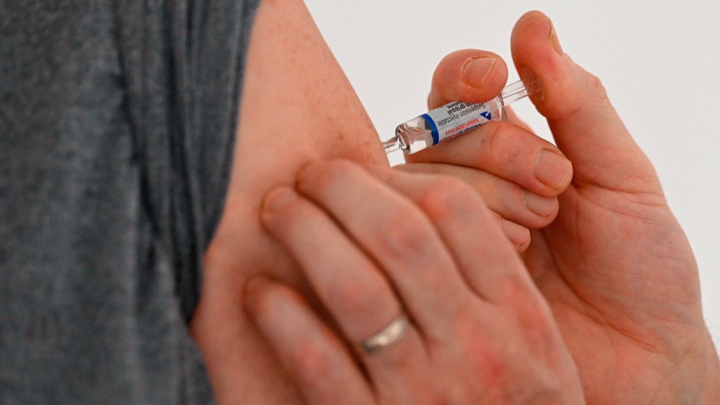 A person gets a flu shot in their upper arm.