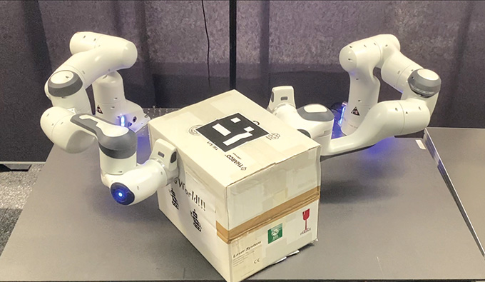 Two white robotic arms grasping a white box.