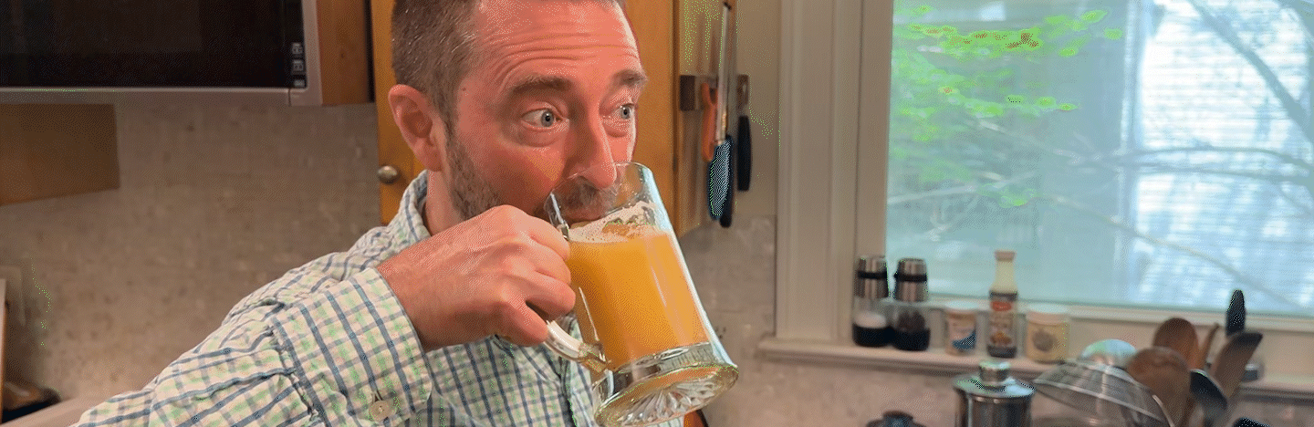 A man takes a sip of beer and has a delighted look on his face.