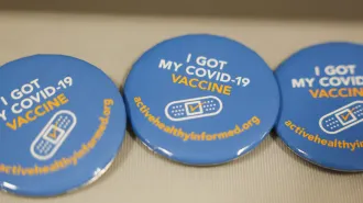 Image of blue pins with I got my COVID-19 vaccine written in white and yellow with a bandaid