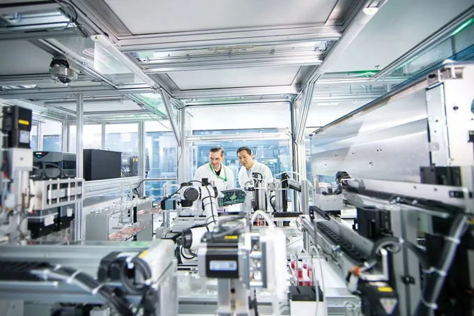 A photo of two people standing inside a lab in Suzhou, China.