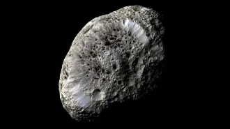 An egg-shaped moon covered in irregular craters on a black background