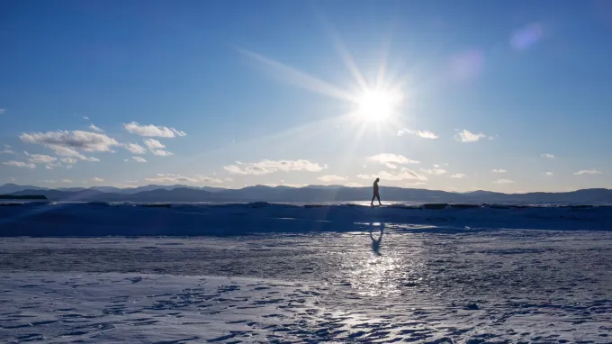 A man walks on frozen Lake Champlain in northern Vermont.