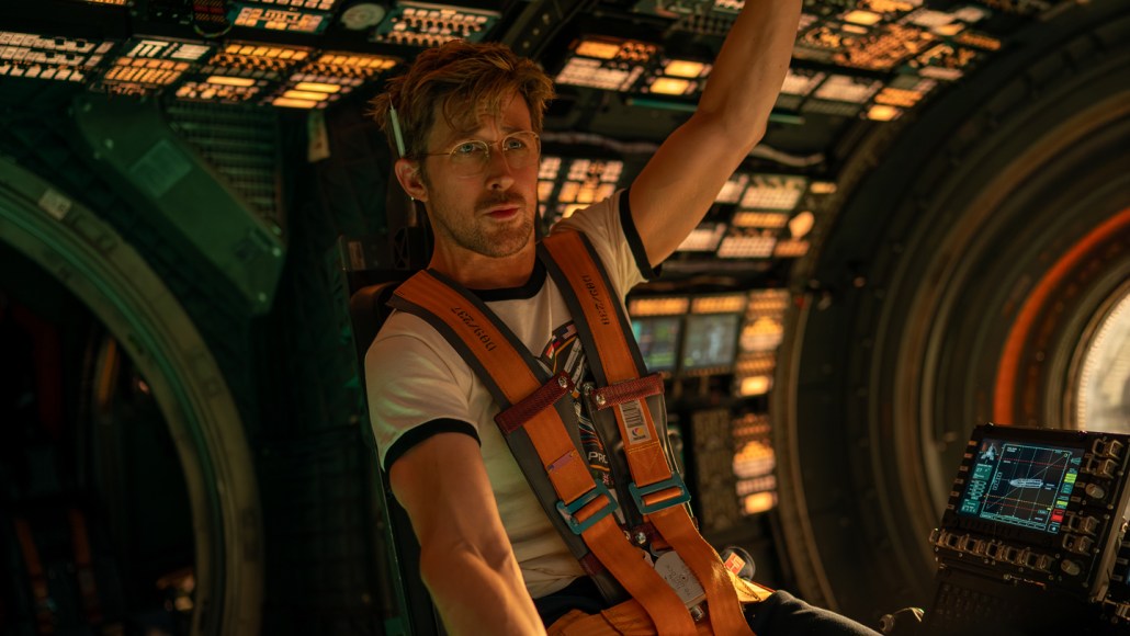 Ryan Gosling sits in a space shuttle's command center