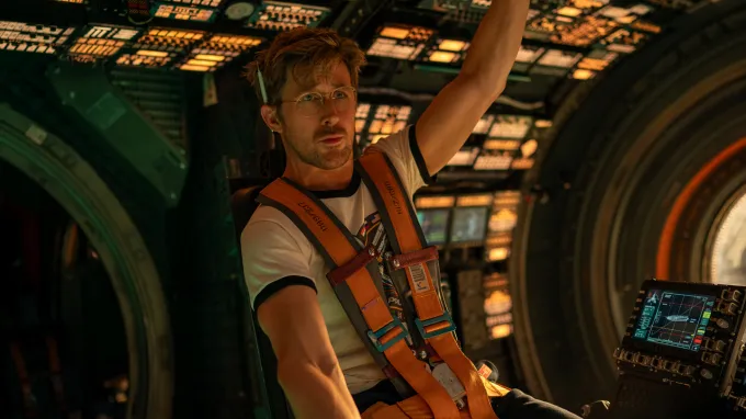 Ryan Gosling sits in a space shuttle's command center