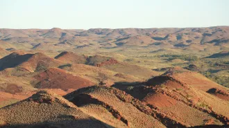 A series of rusty-colored hills stretch into the distance. Rocks here hold the earliest known evidence of plate tectonics, a new study says.