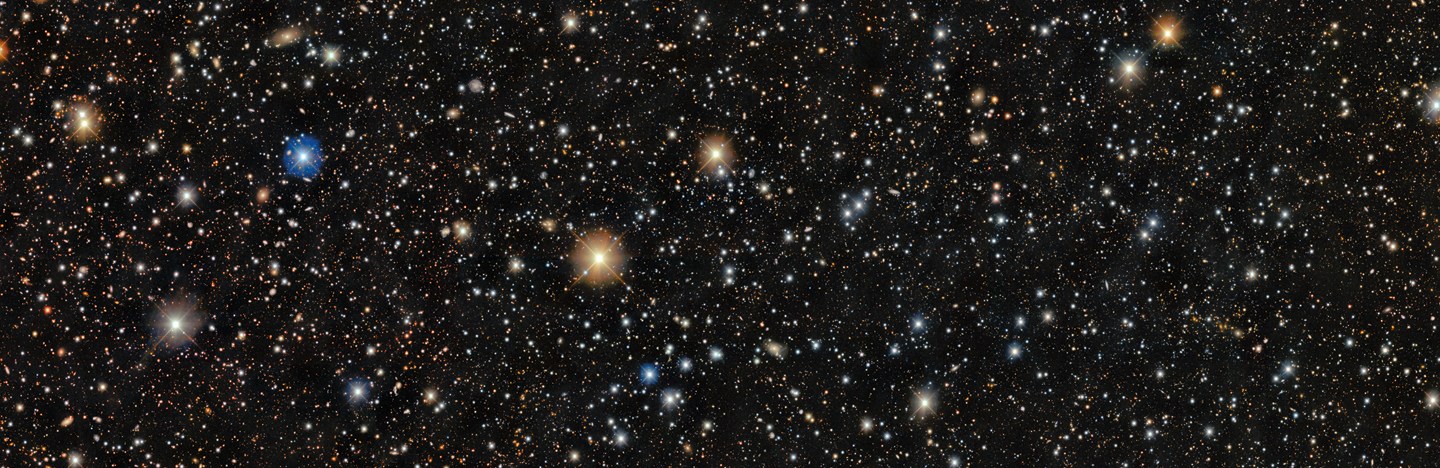 A dense star field shows thousands of stars of varying colors and brightness scattered across a dark background.