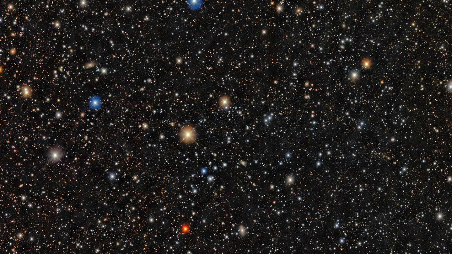 A dense star field shows thousands of stars of varying colors and brightness scattered across a dark background.