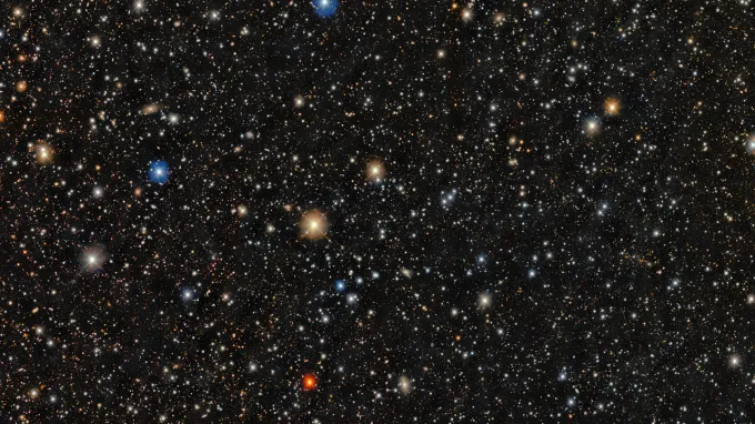 A dense star field shows thousands of stars of varying colors and brightness scattered across a dark background.