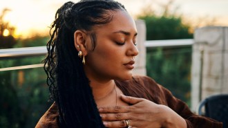 A woman holds her hand to her chest.