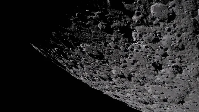 The craggy, cratered surface of the moon with deep shadows
