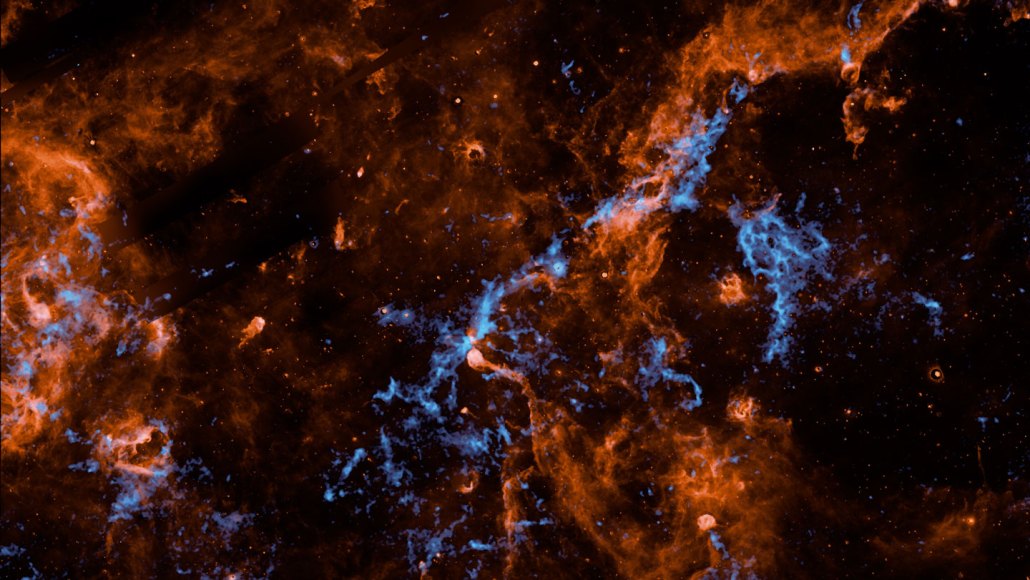 Wispy red and blue clouds form a tie-dye pattern in this false color image of a stellar nursery.