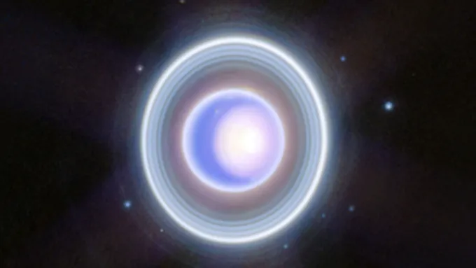 Uranus appears as a pale blue disk encircled by several faint, bright rings.