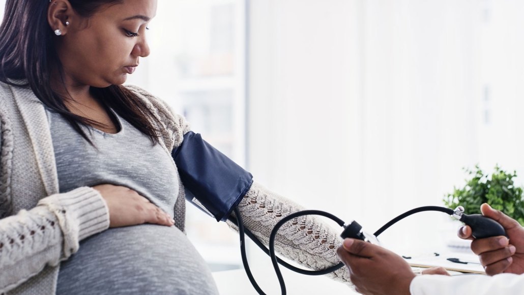 A pregnant woman has her blood pressure measured.