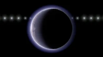 A distant icy world appears as a dark disk with a thin glowing halo, with a line of repeated bright points showing a distant star at multiple positions.