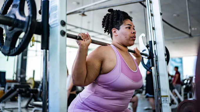 A woman lifts weights, a type of friction worth keeping.
